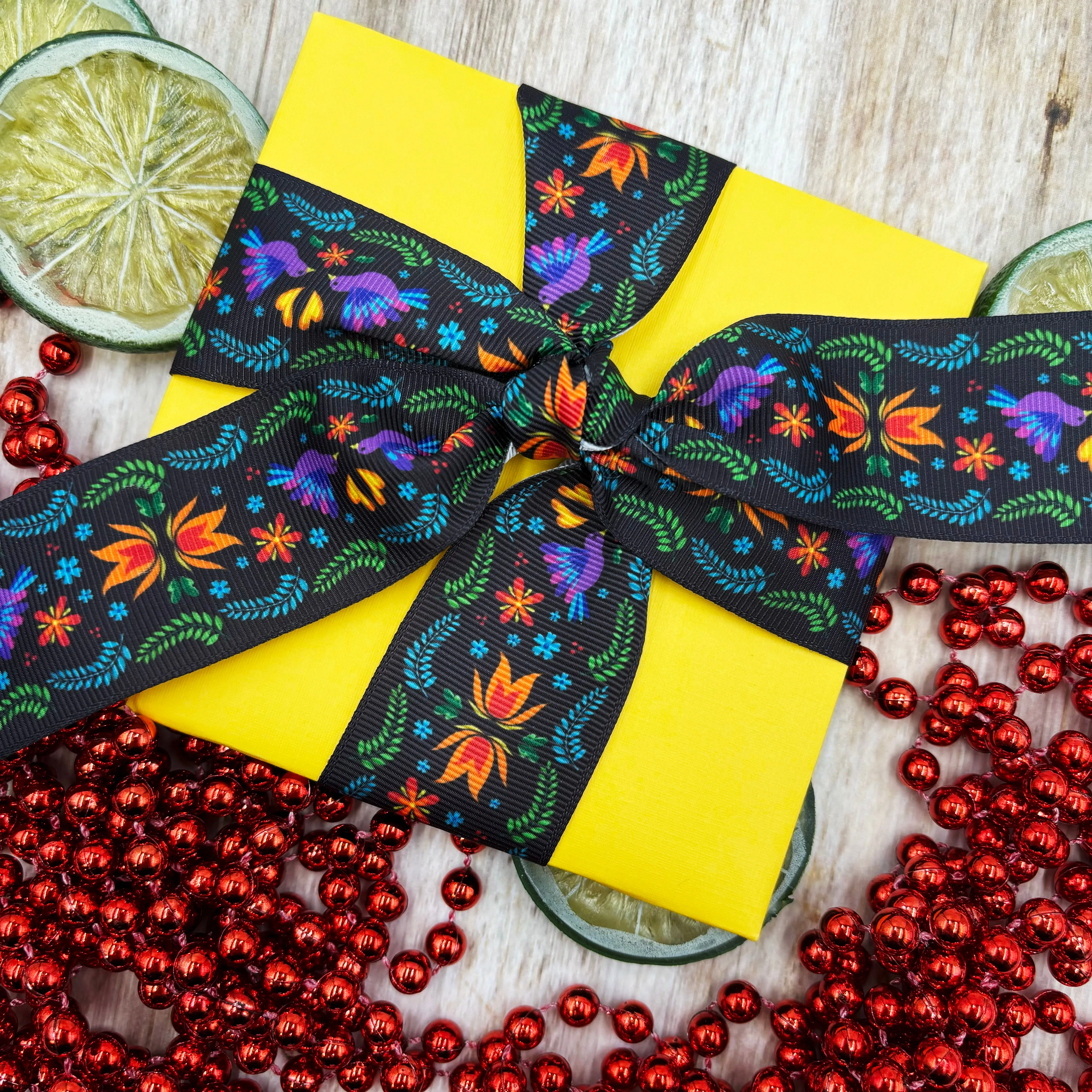 Mexican Floral Ribbon flowers of orange and turquoise with purple birds and green flora on a black background printed on 1.5" satin and grosgrain